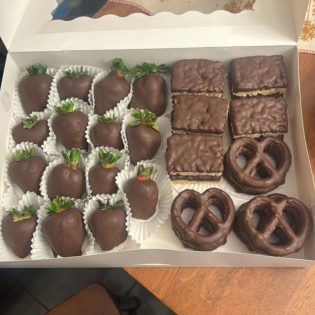 Large generous gift box packed with chocolate-covered strawberries, Rice Krispie bars, and pretzels in classic plain dark chocolate for the holidays.